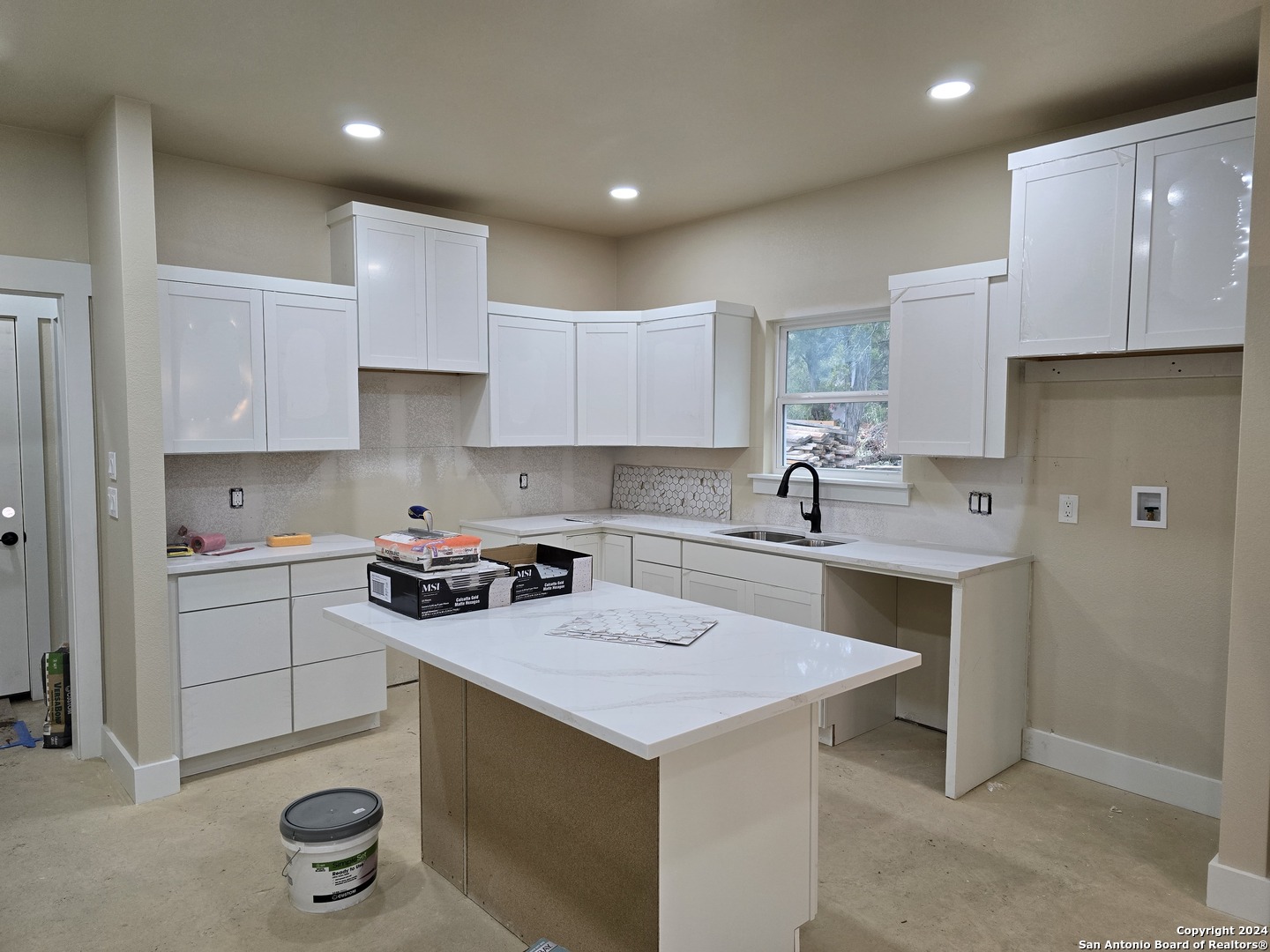 a kitchen with a sink a stove a refrigerator and cabinets