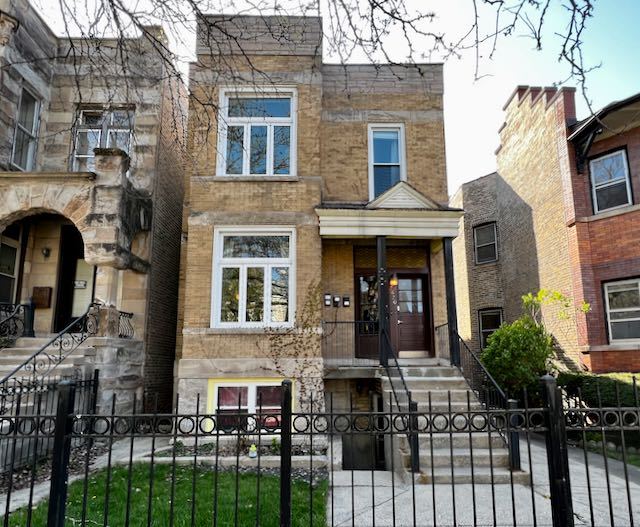 front view of a brick house with a yard