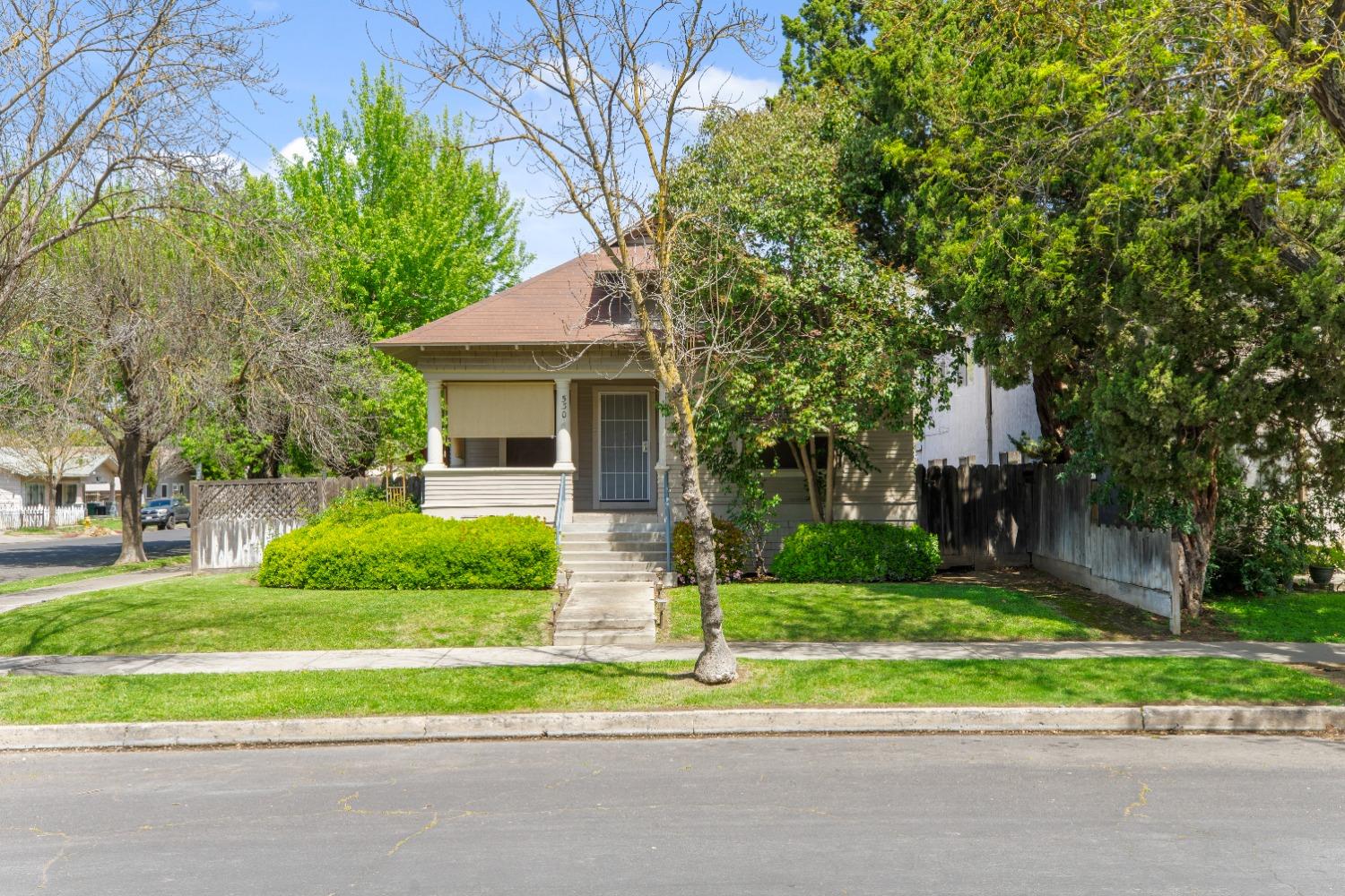 a front view of a house with a yard and potted plants