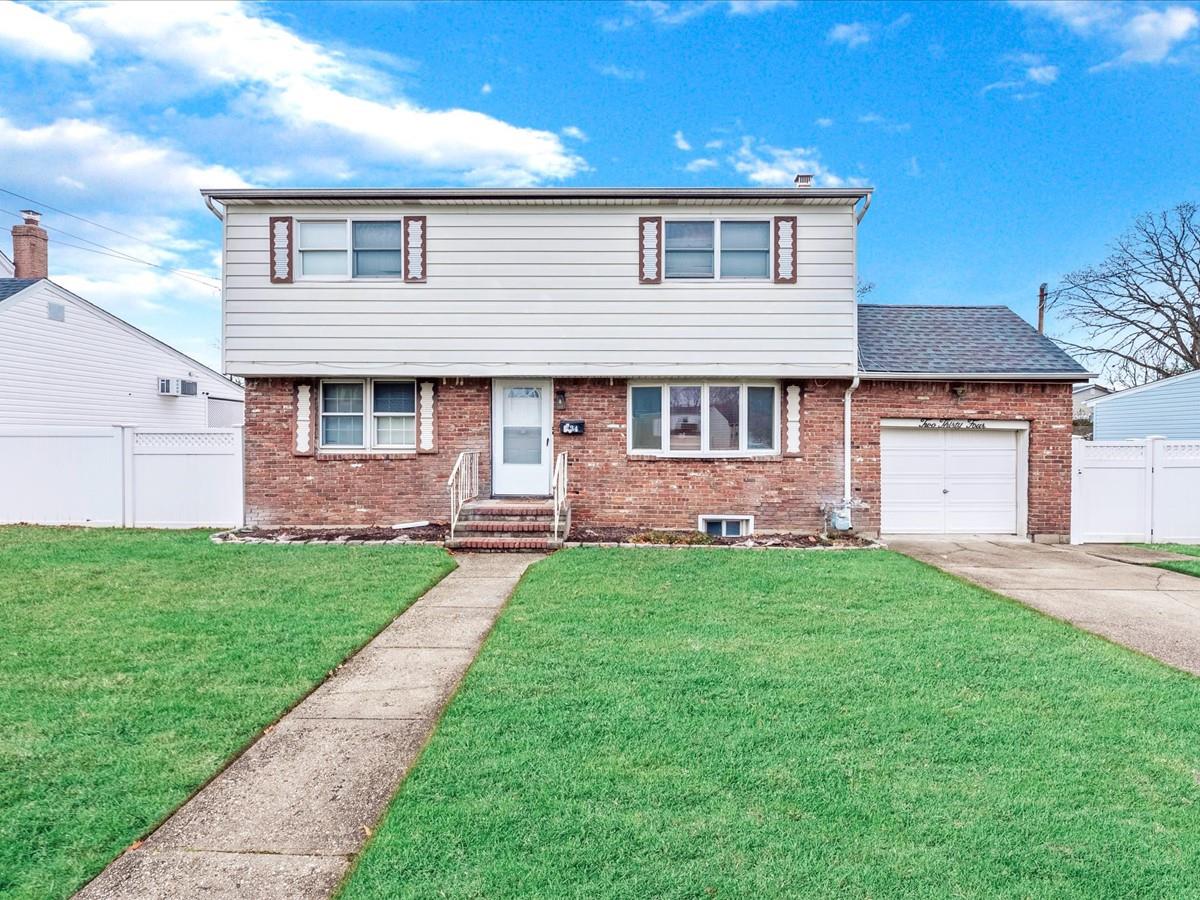 Front facade with a garage and a front lawn