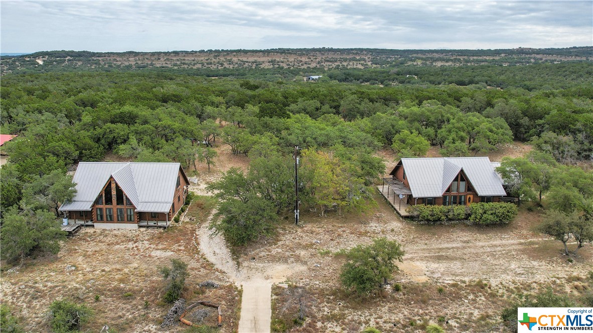 an aerial view of a house with a yard and lake view