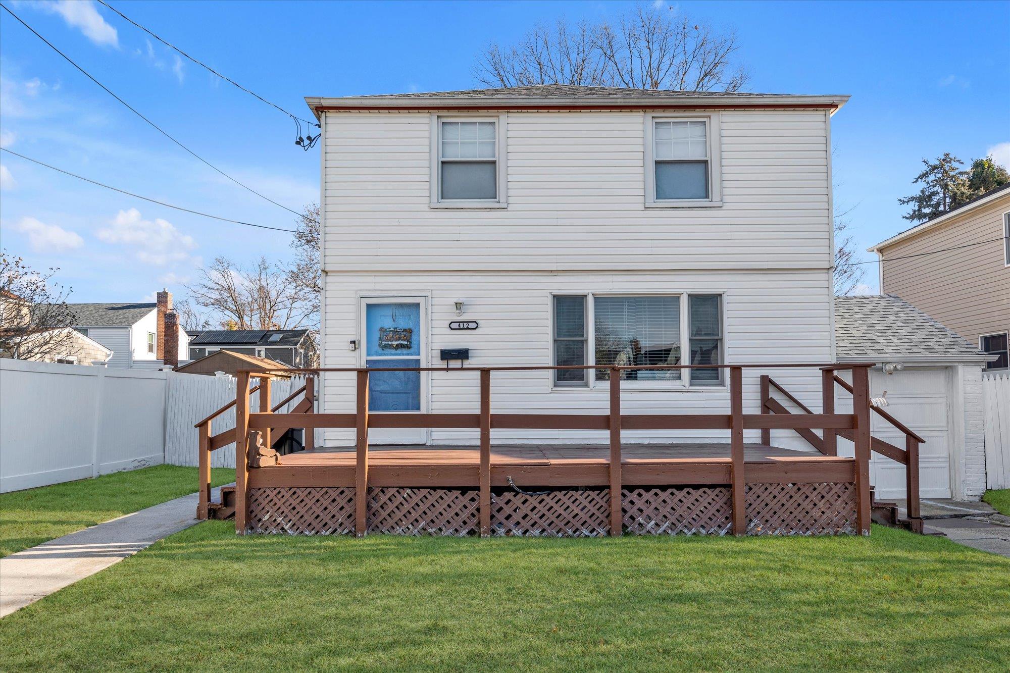 Back of property with a yard and a deck