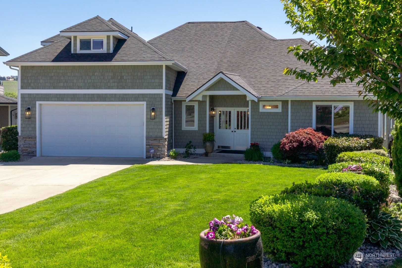 a front view of a house with a yard and garage