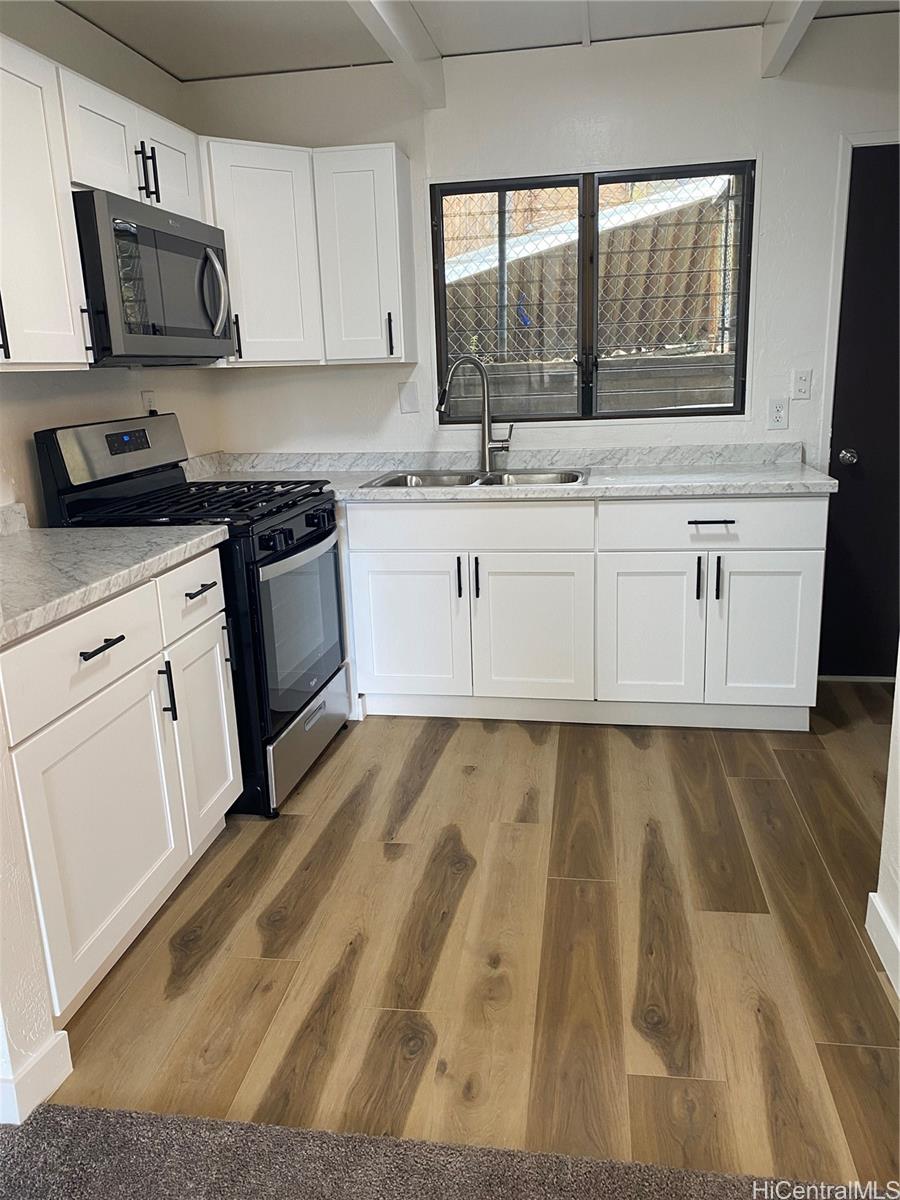 a kitchen with granite countertop a sink and a stove top oven