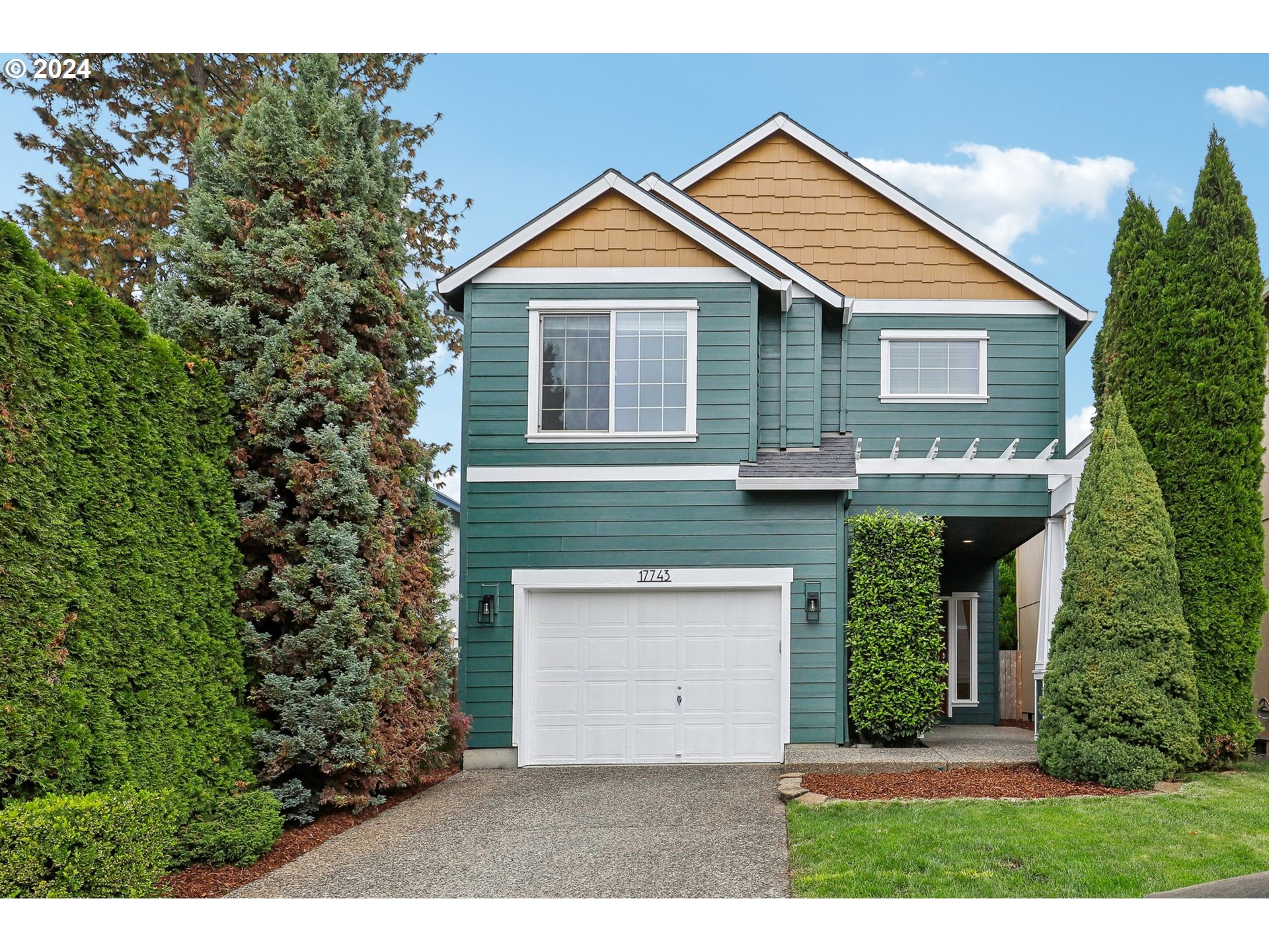 a front view of a house with a garden and garage