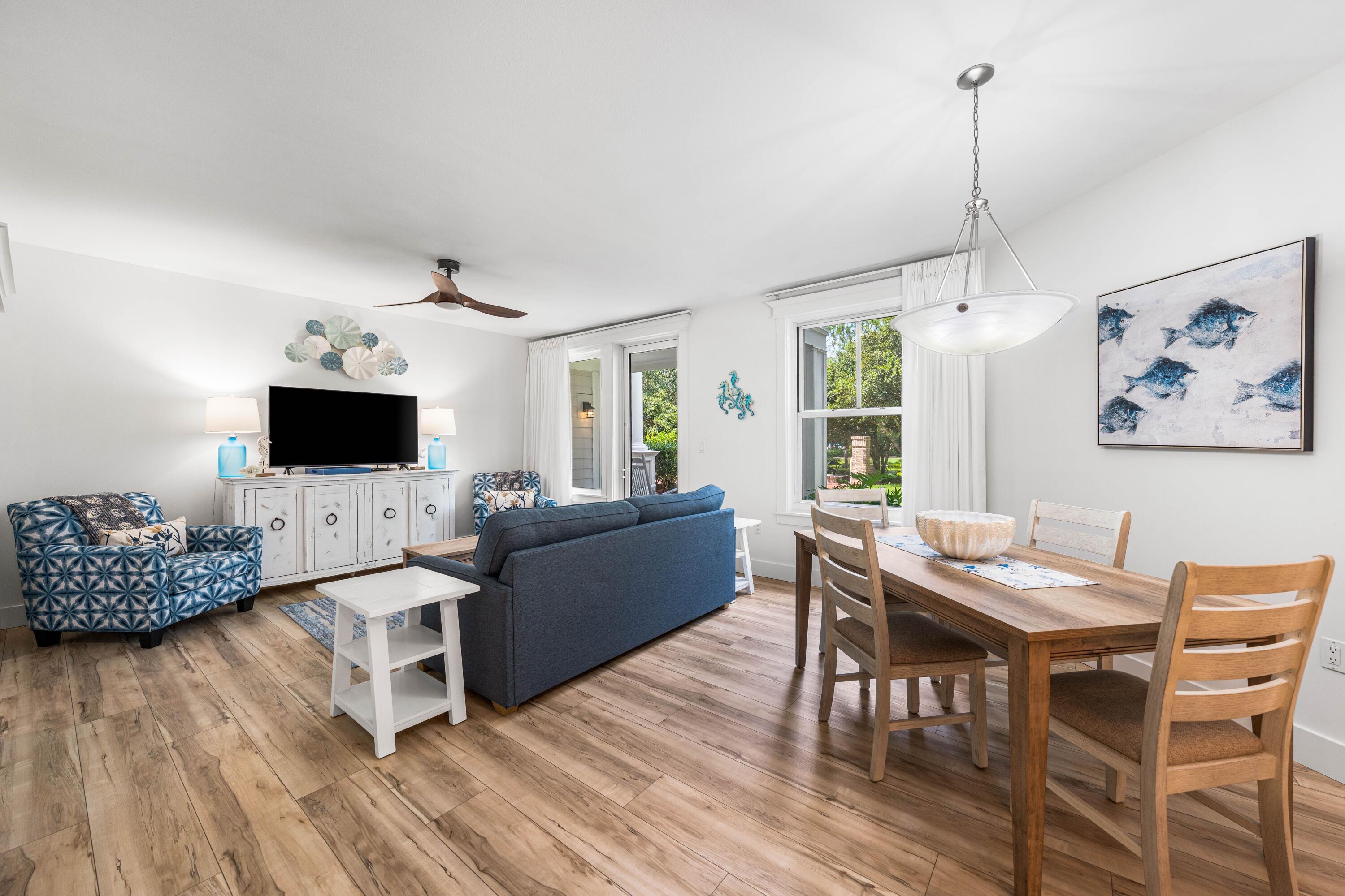 a living room with furniture a flat screen tv and a wooden floor