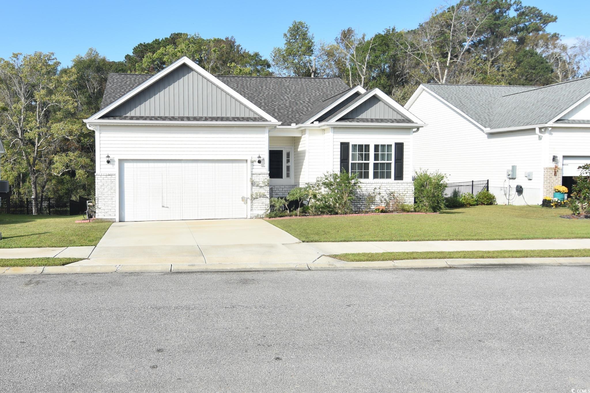 View of front of home with a garage and a front ya