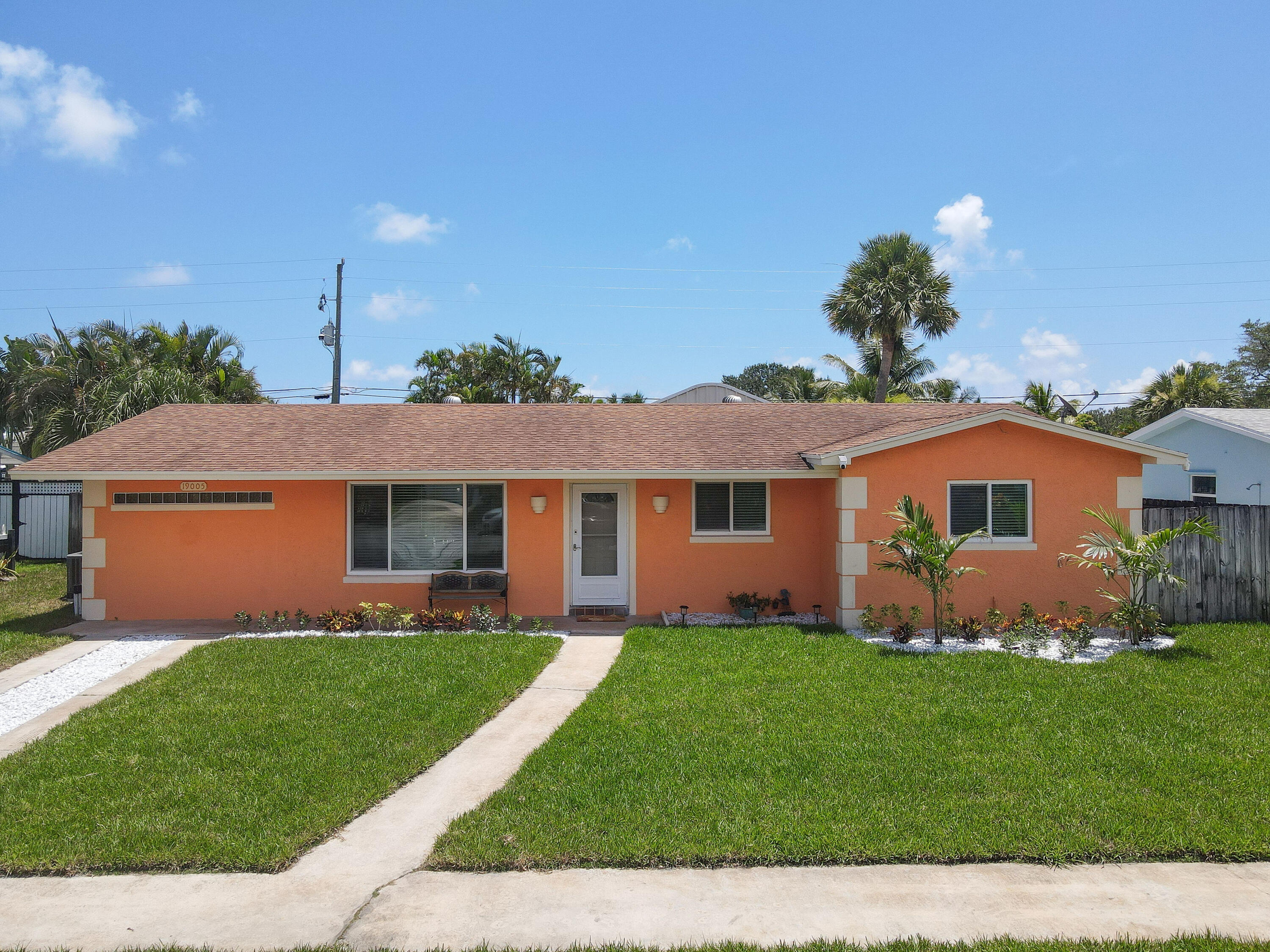 a front view of a house with a garden and yard