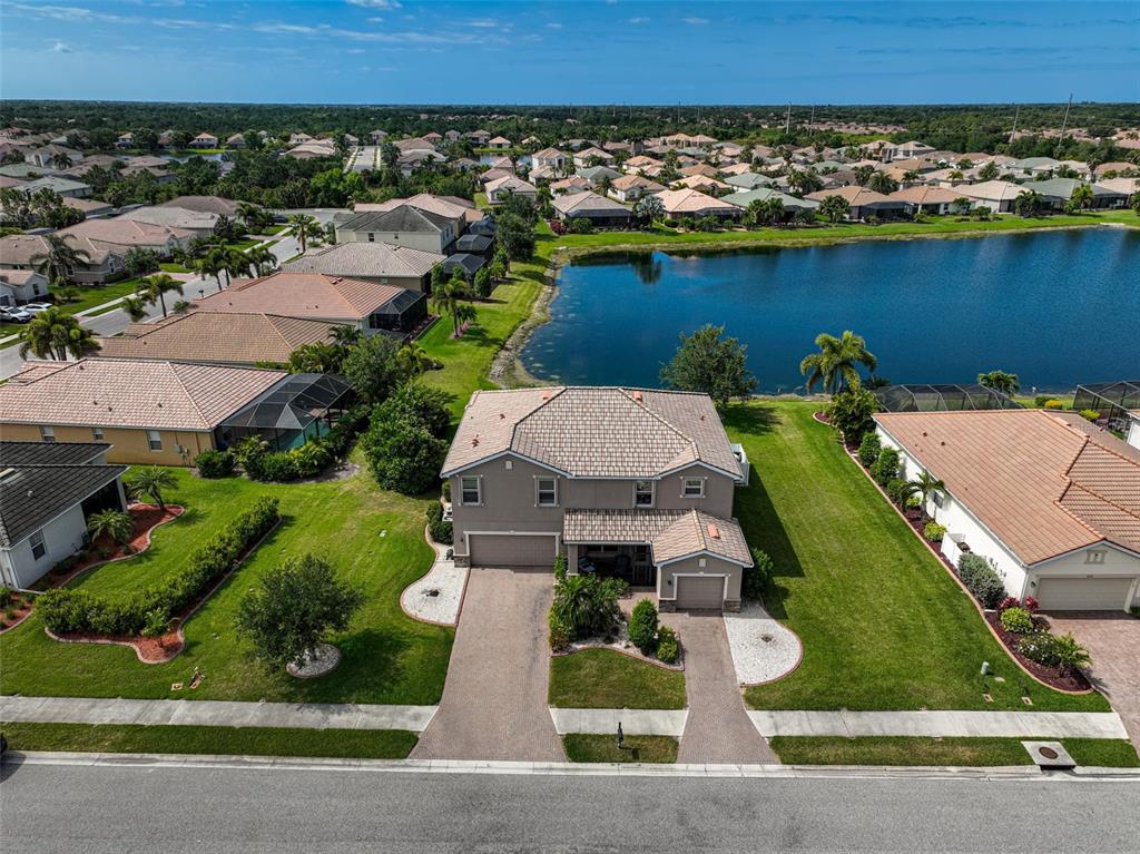 an aerial view of a house with a garden and lake view