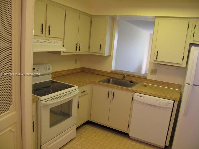 a view of a kitchen with sink washer and dryer