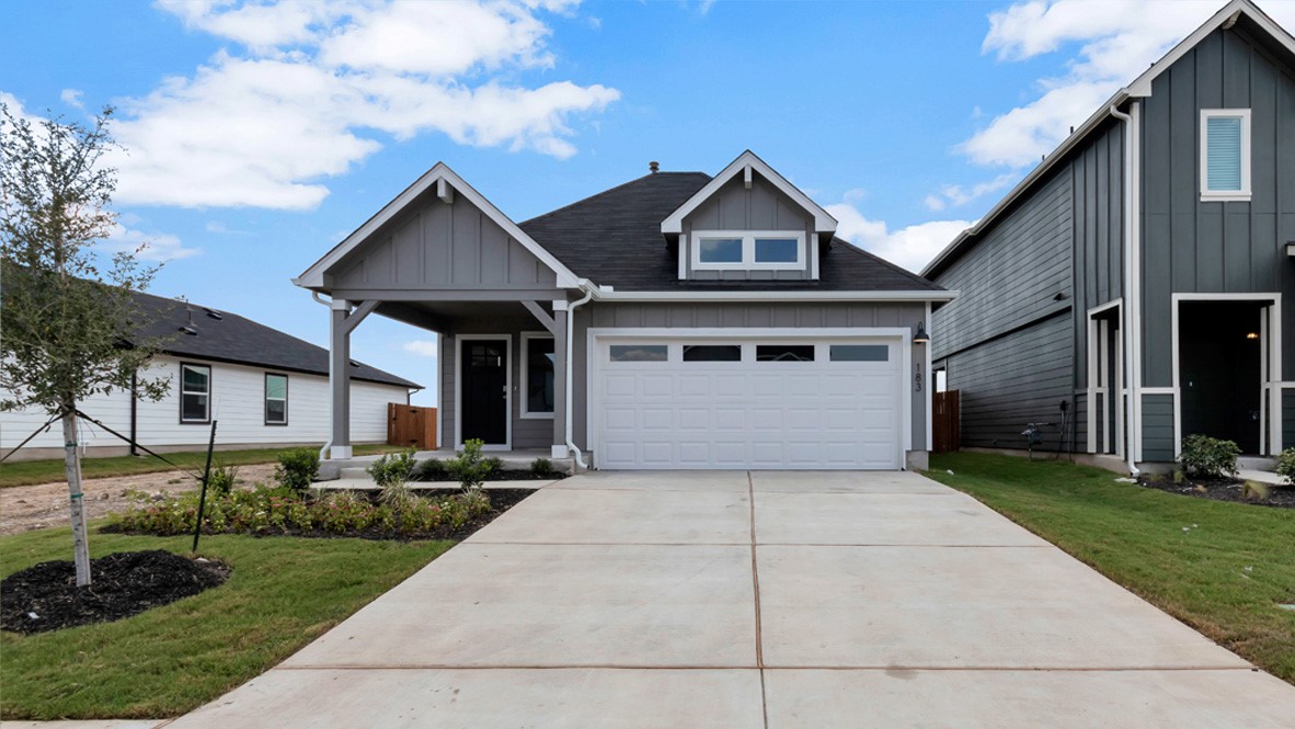 a front view of a house with a yard and garage