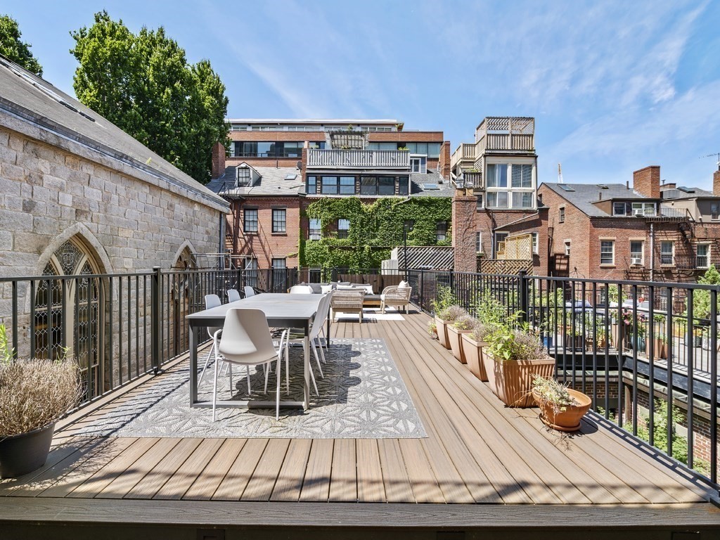 a view of a balcony with dining table and chairs with wooden floor