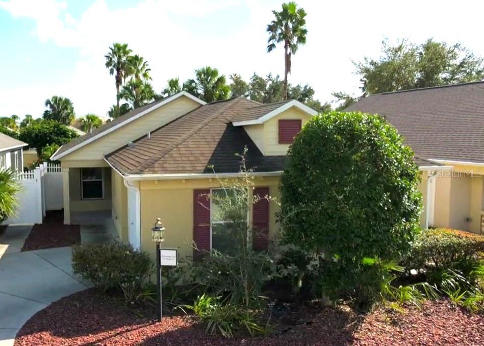 a view of a house with a yard and potted plants