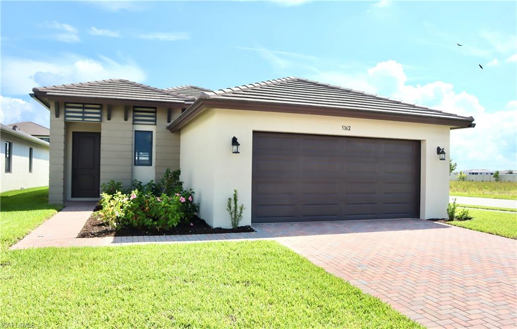 a front view of a house with a yard and garage