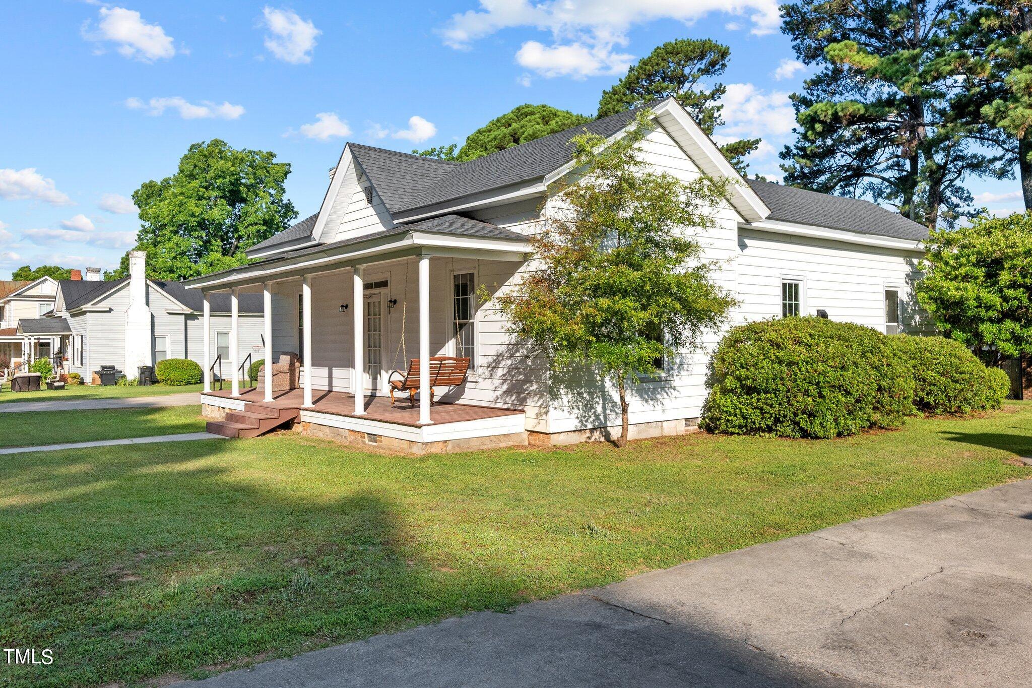 a view of a house with a yard and sitting area