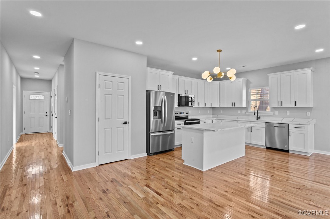 Kitchen with white cabinets, a center island, and