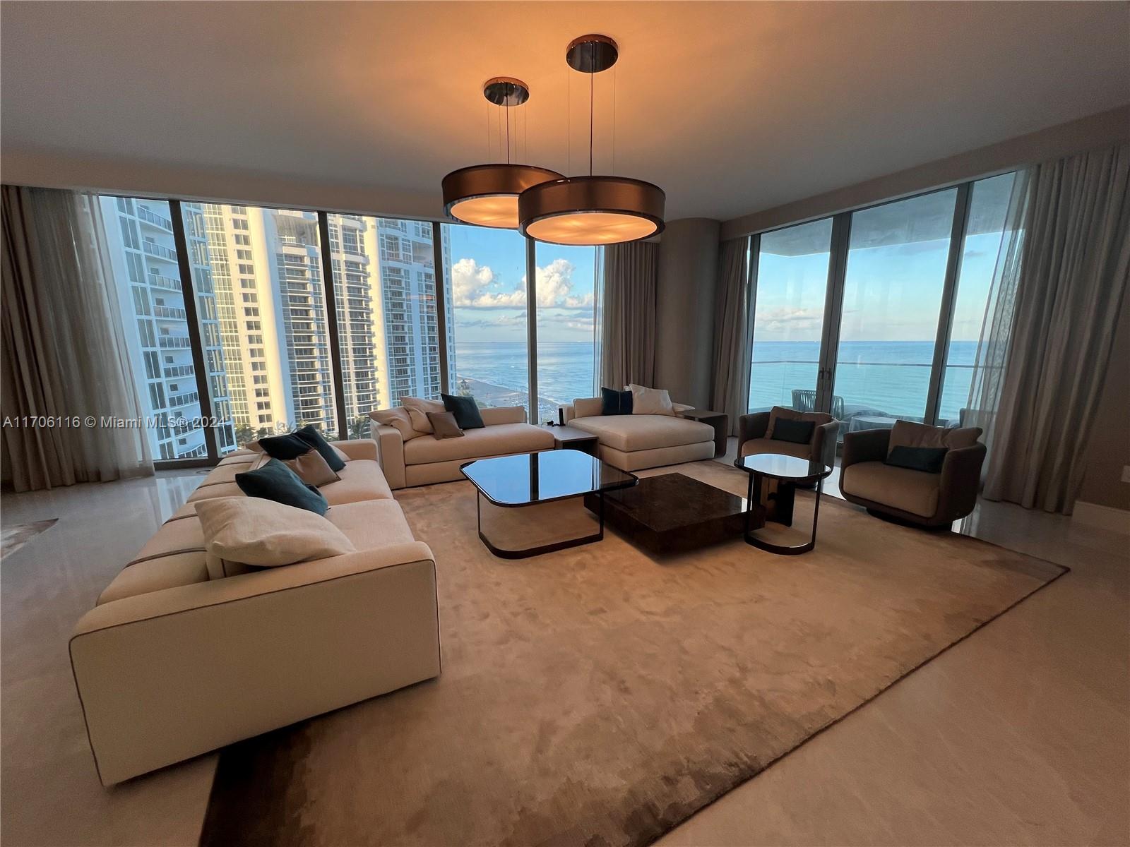 a living room with furniture and large windows