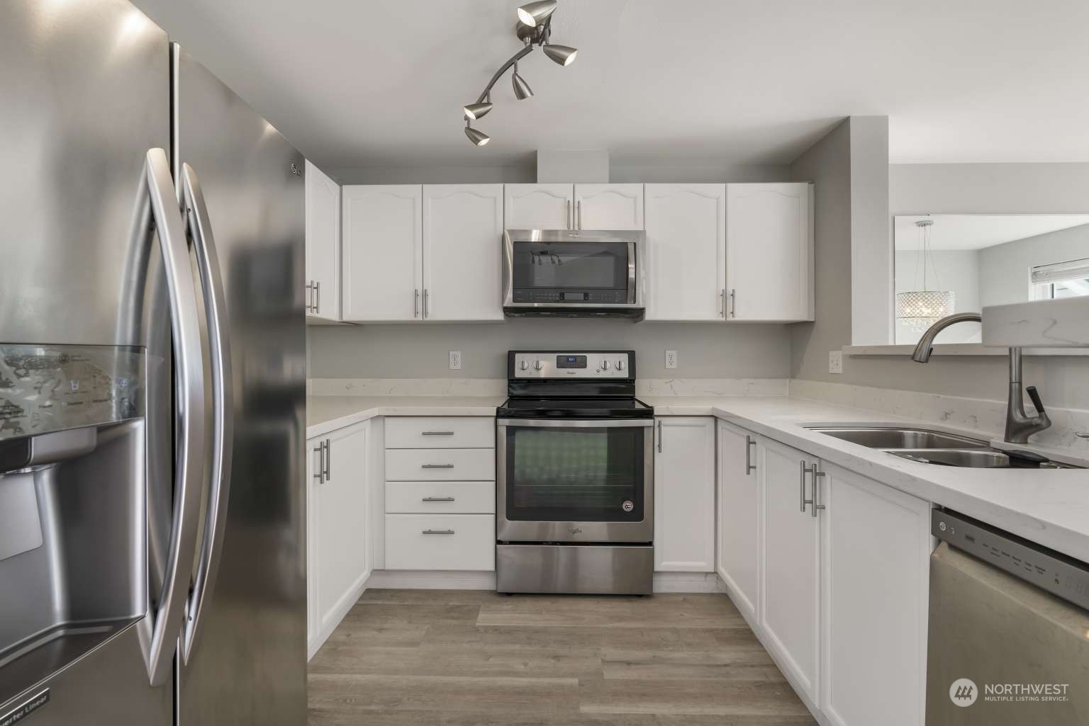 a kitchen with stainless steel appliances a refrigerator sink and microwave