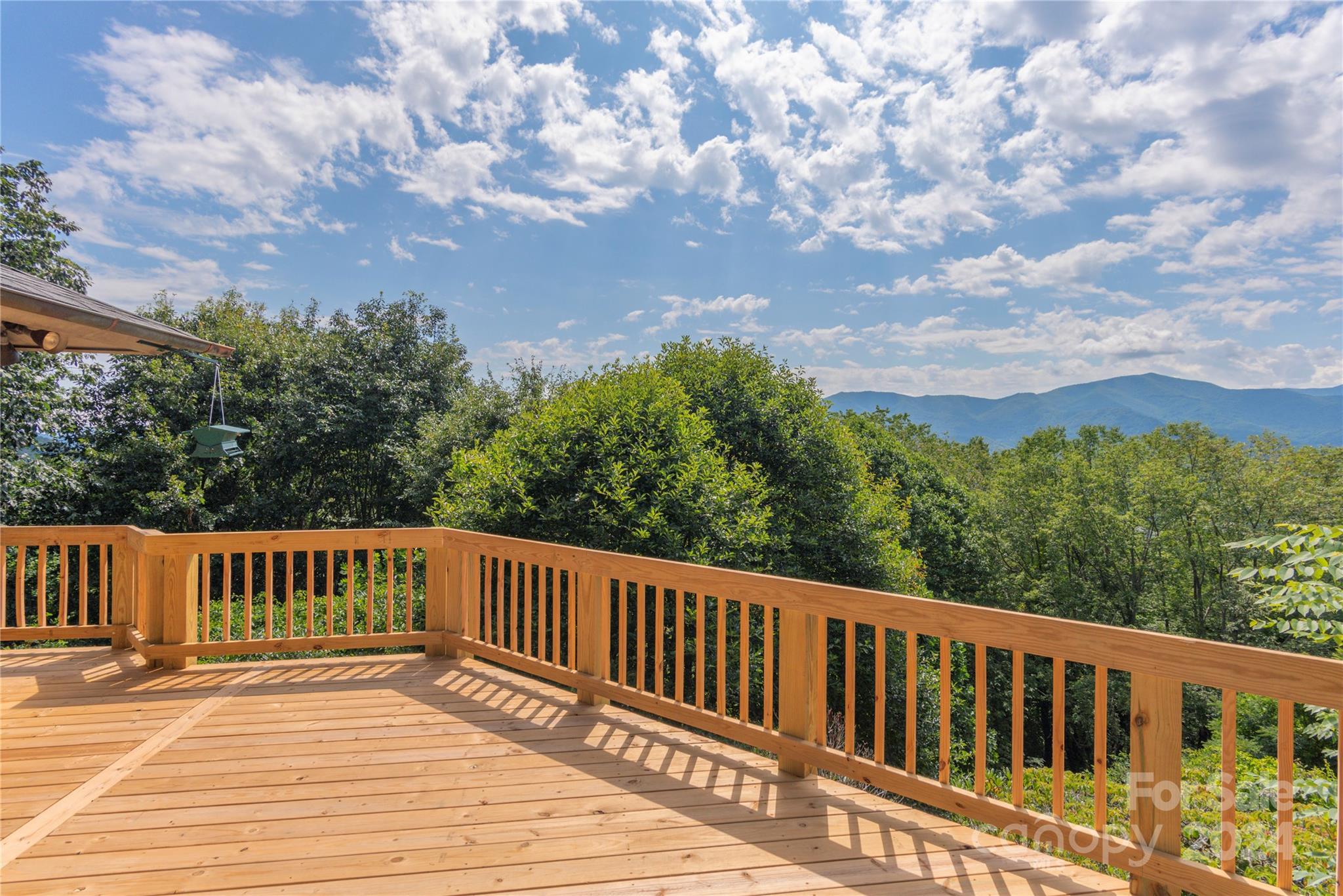 a view of a wooden deck with trees in the background