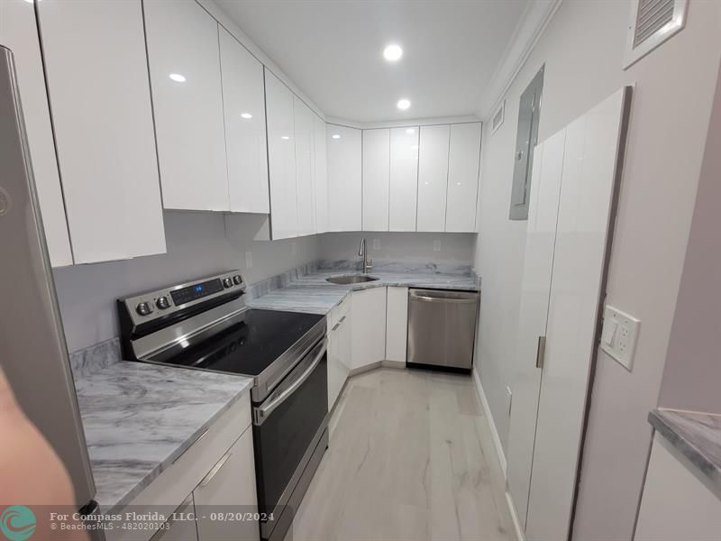 a kitchen with a white stove a sink and dishwasher