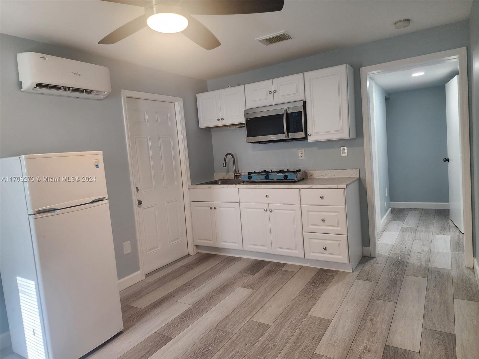 a kitchen with stainless steel appliances a refrigerator sink and microwave