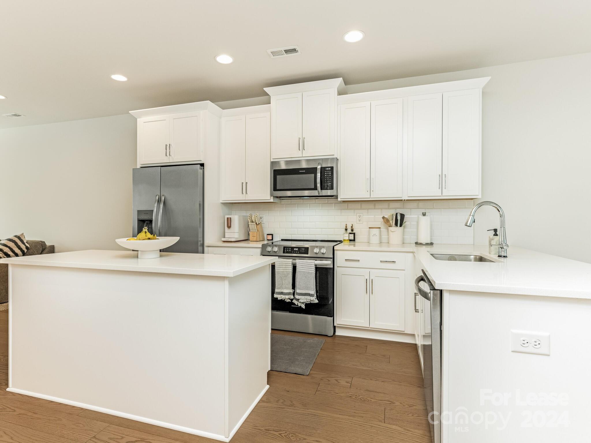 a kitchen with a sink a stove and a refrigerator