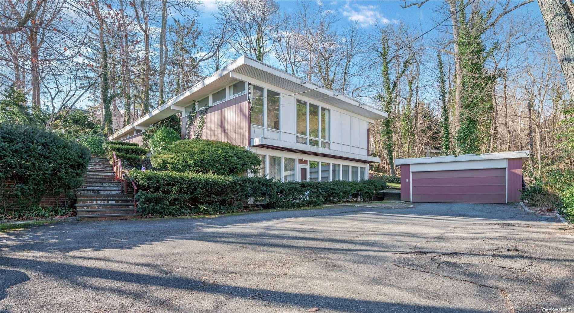 a front view of a house with a yard and trees