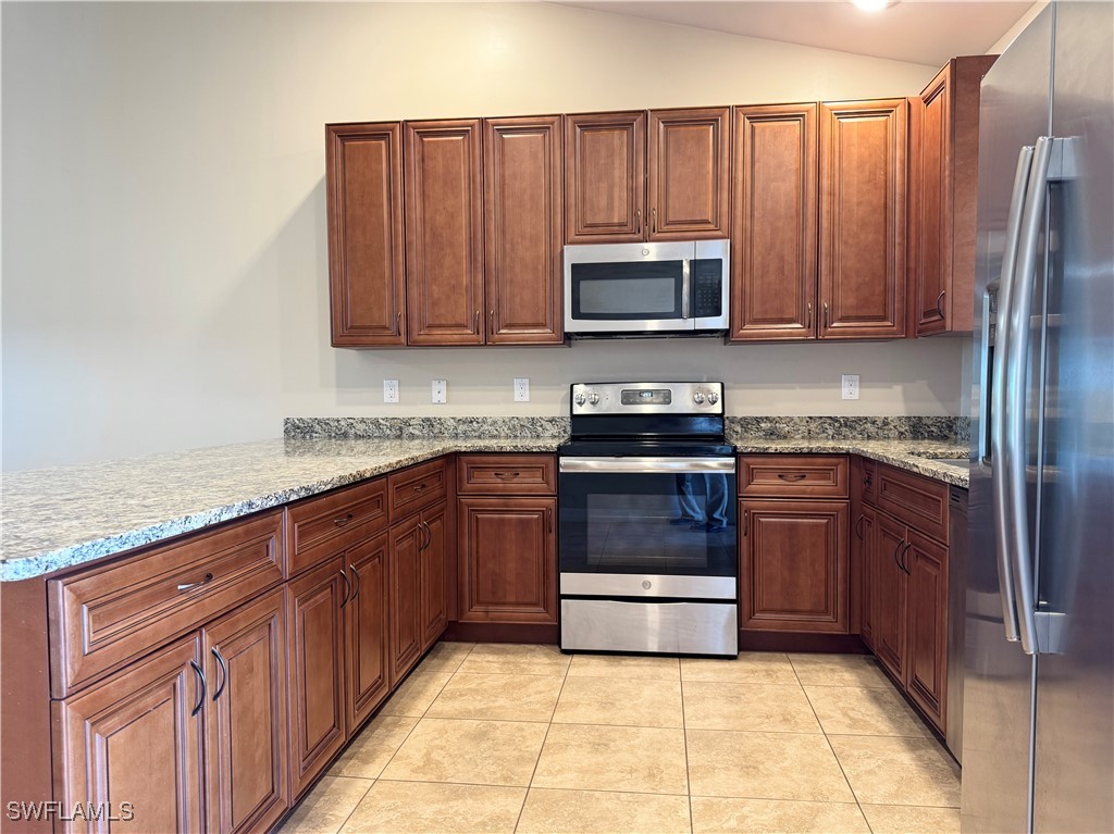 a kitchen with stainless steel appliances granite countertop a refrigerator stove and sink