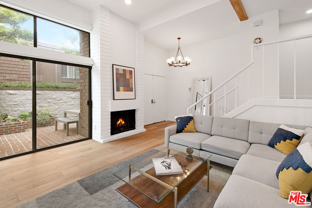 a living room with furniture a fireplace and a large window