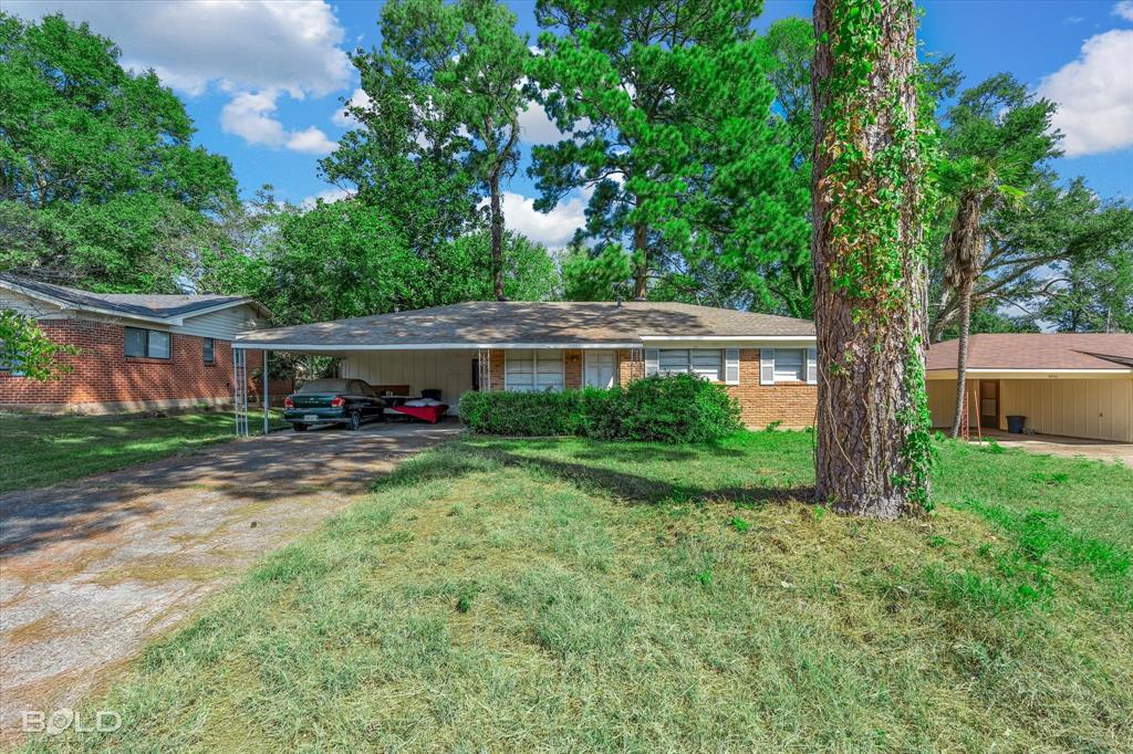 a view of a house with backyard and a patio