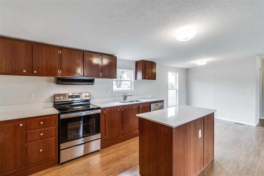 a kitchen with stainless steel appliances granite countertop a stove a sink and a microwave