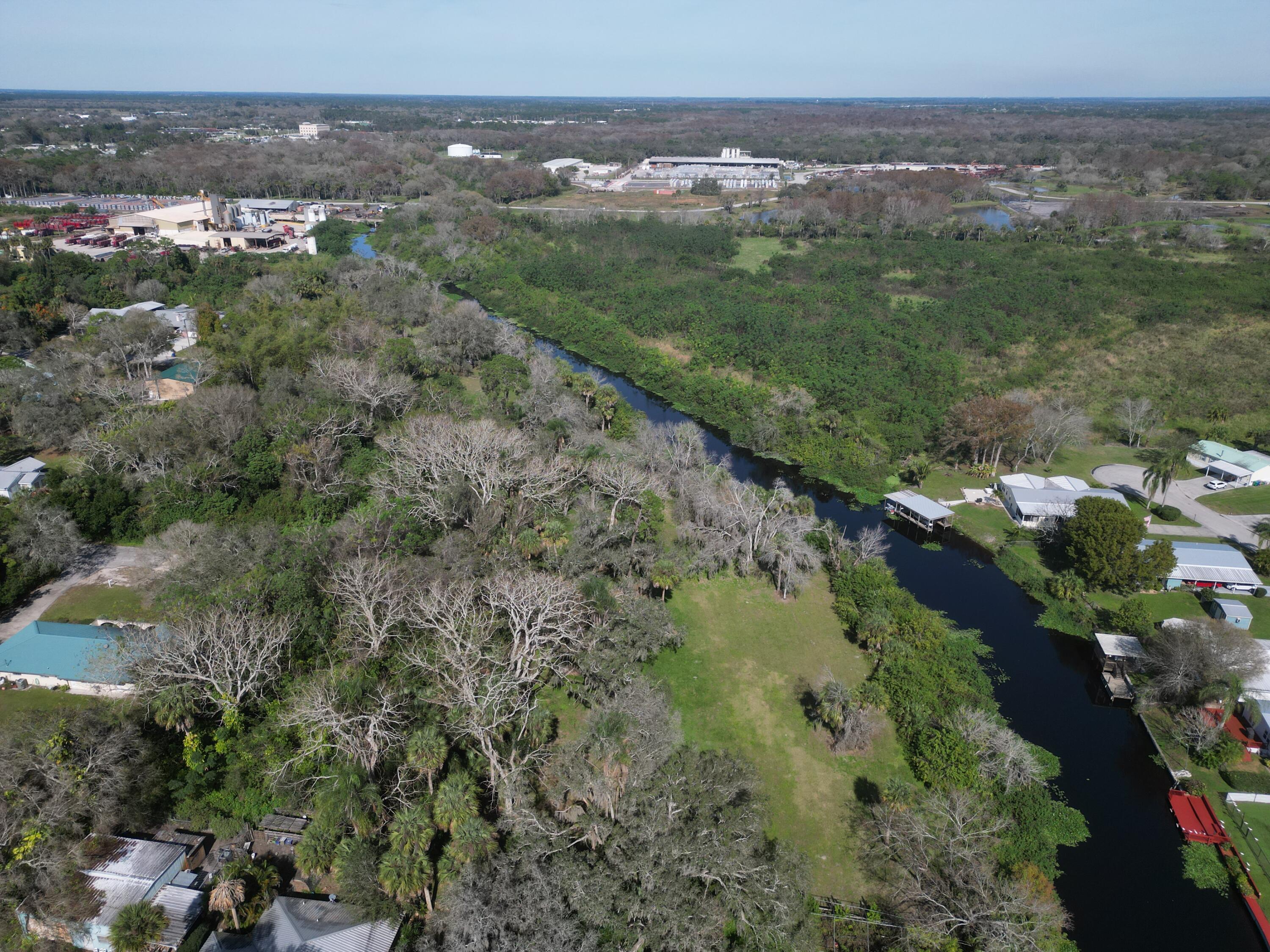 an aerial view of residential houses with outdoor space and trees