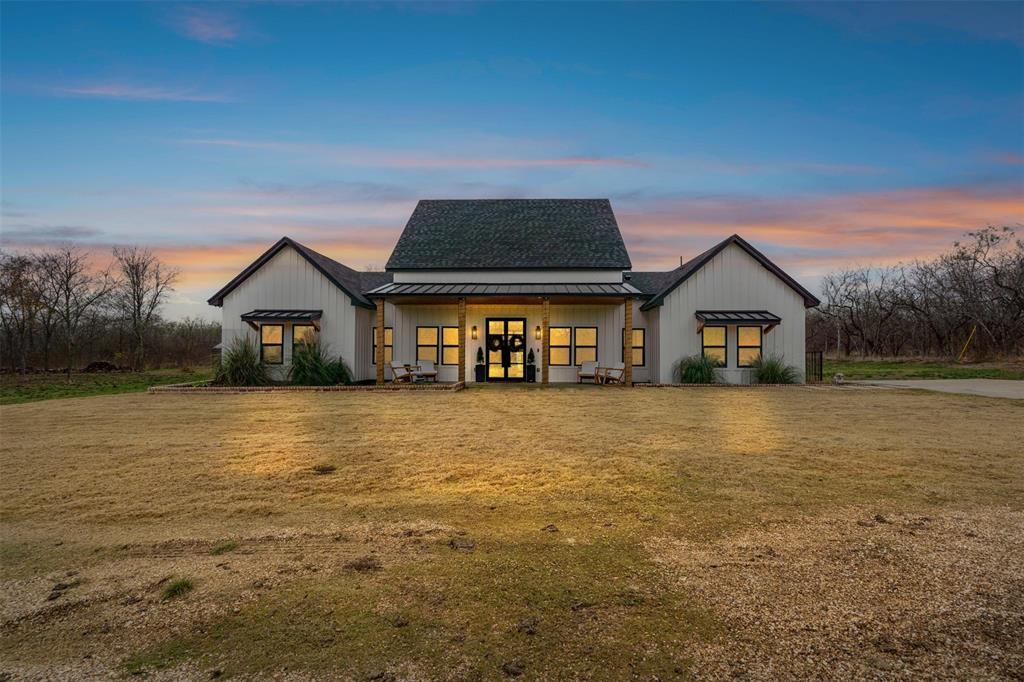 a front view of a house with a yard and lake view