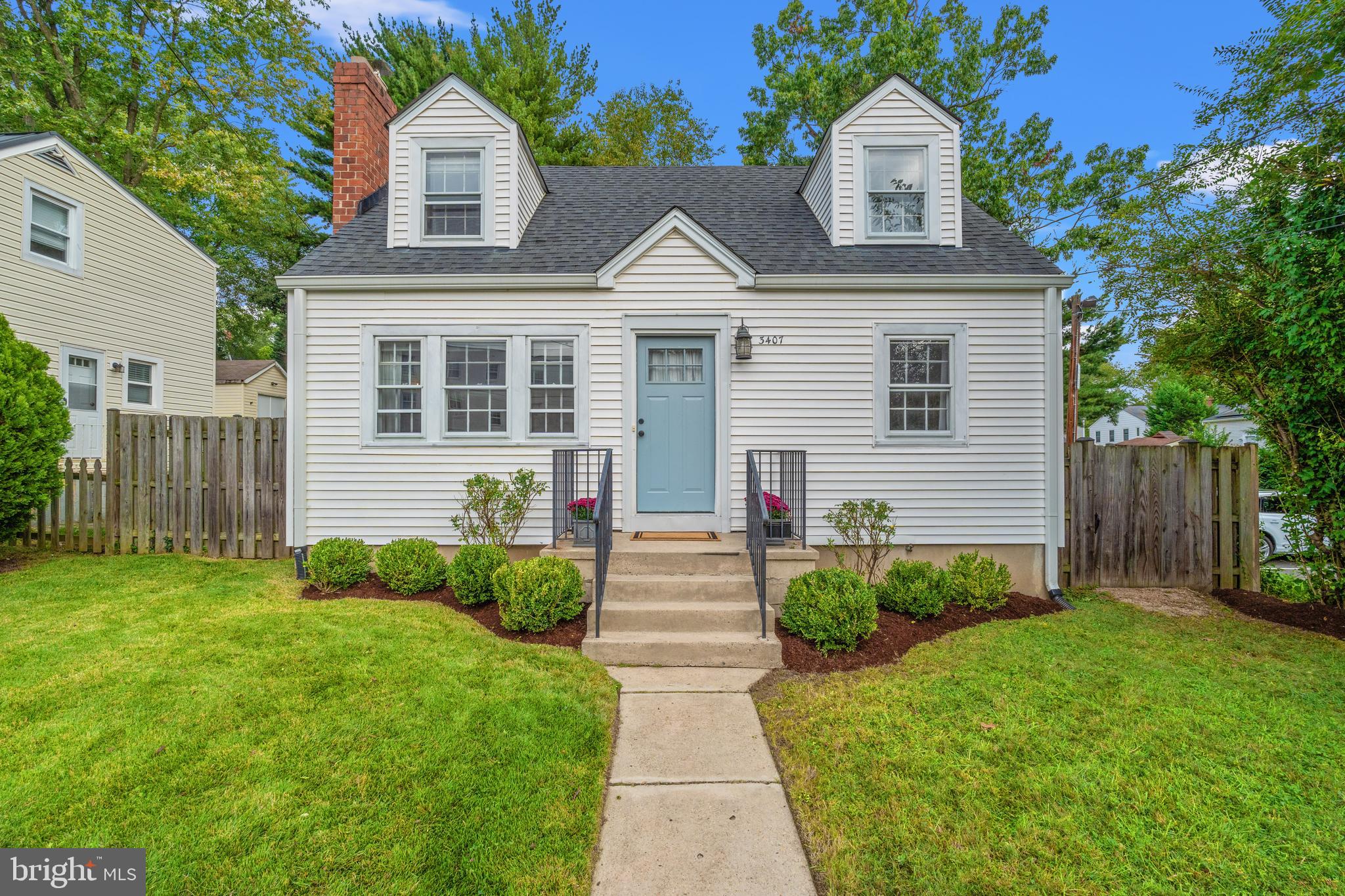 a front view of a house with a yard and trees