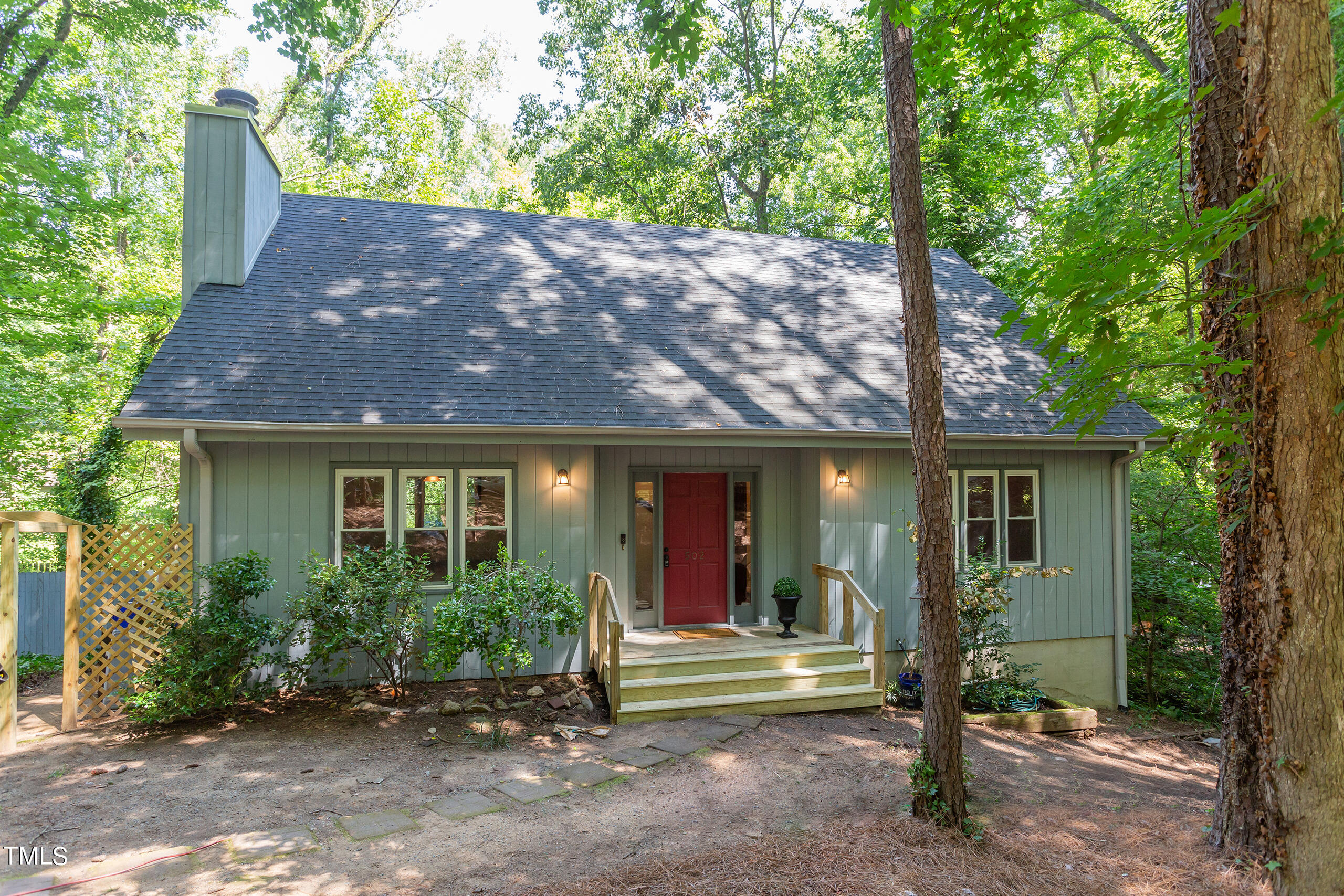 a view of a house with backyard and a tree