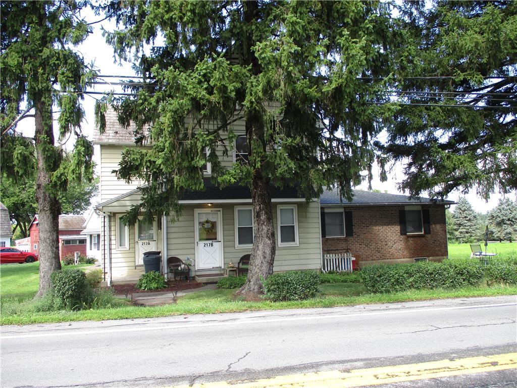 a front view of a house with a garden and plants