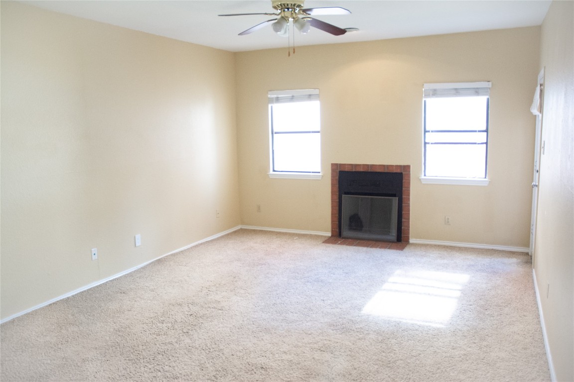 an empty room with a window and a ceiling fan