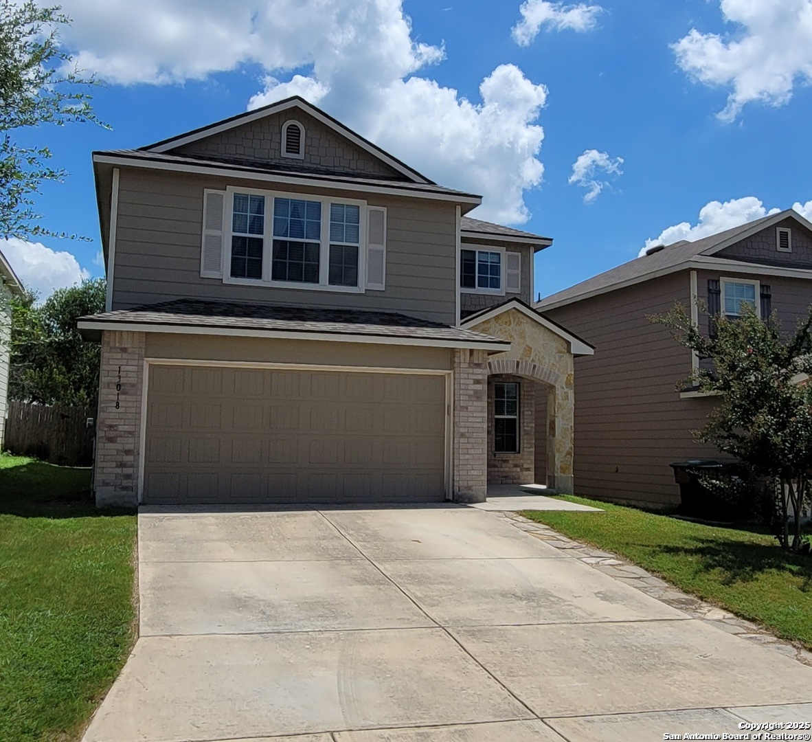 a front view of a house with a yard and garage