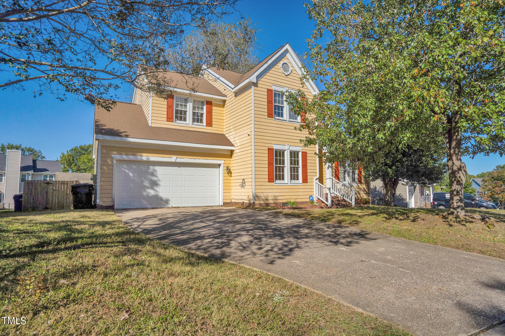 a view of a house with a yard and large tree