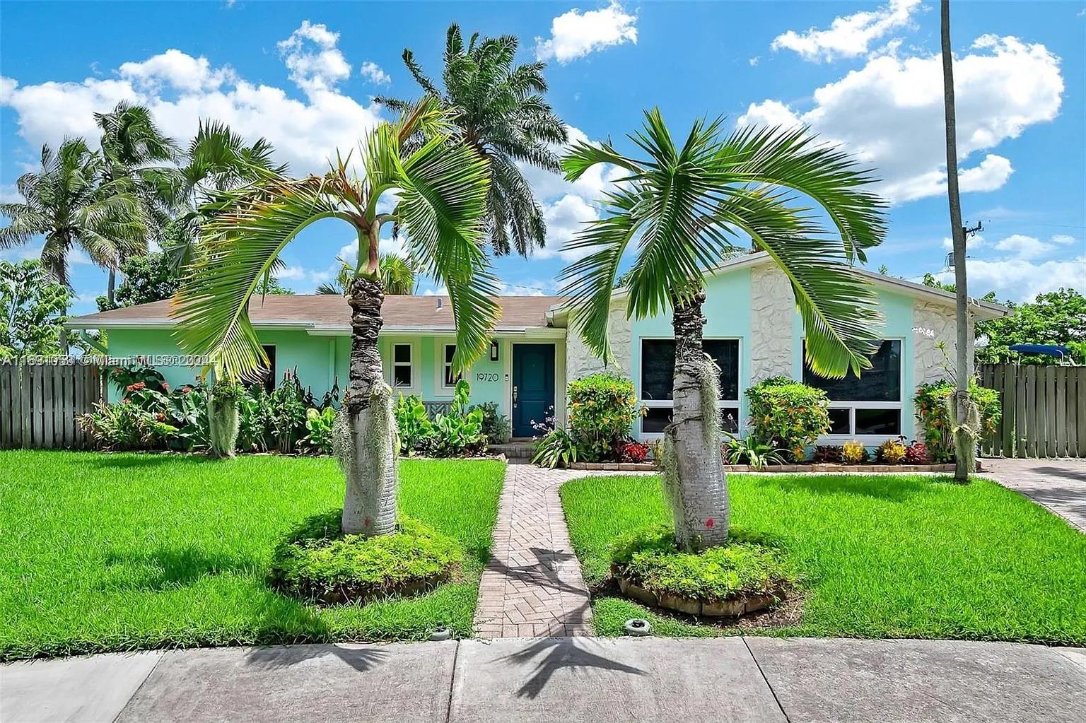 a front view of a house with a yard and potted plants