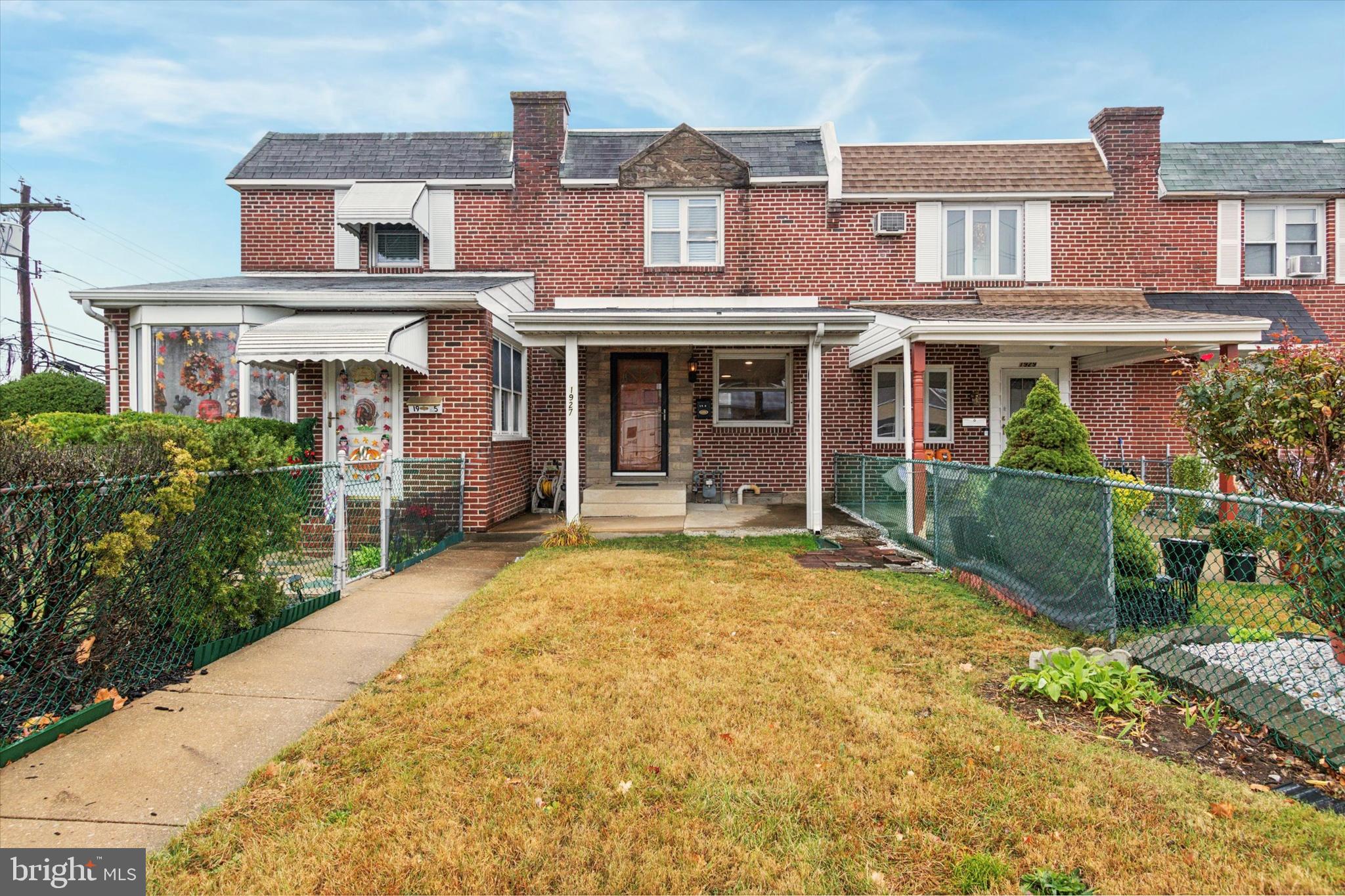 front view of a brick house with a yard