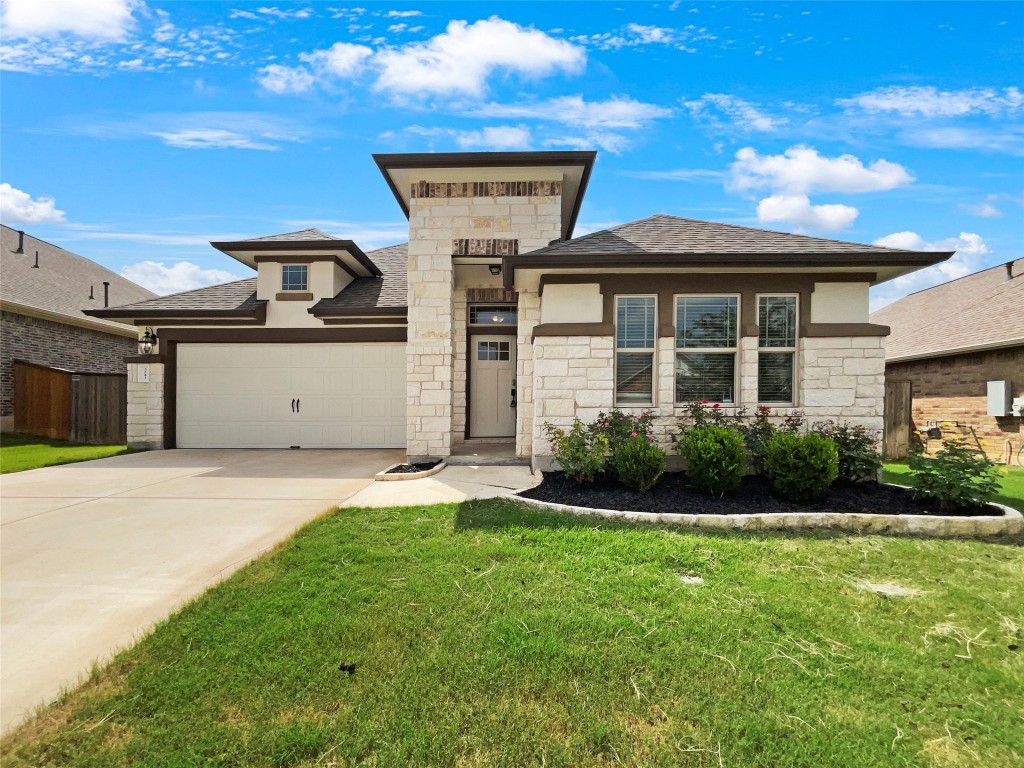 a front view of a house with a yard and garage