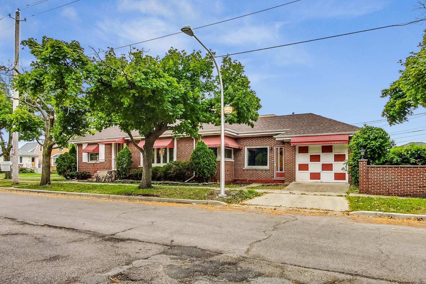 a front view of a house with a yard and potted plants