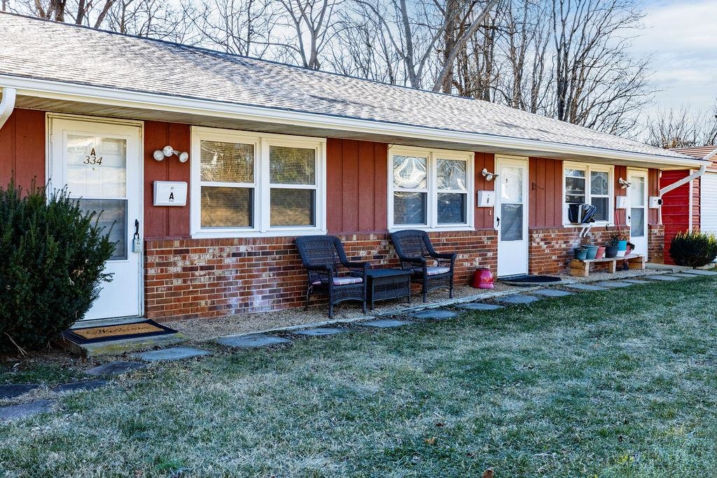 a view of a house with a backyard and sitting area