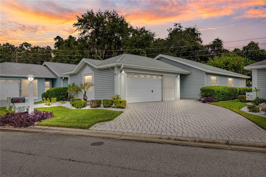 a front view of a house with a yard and trees