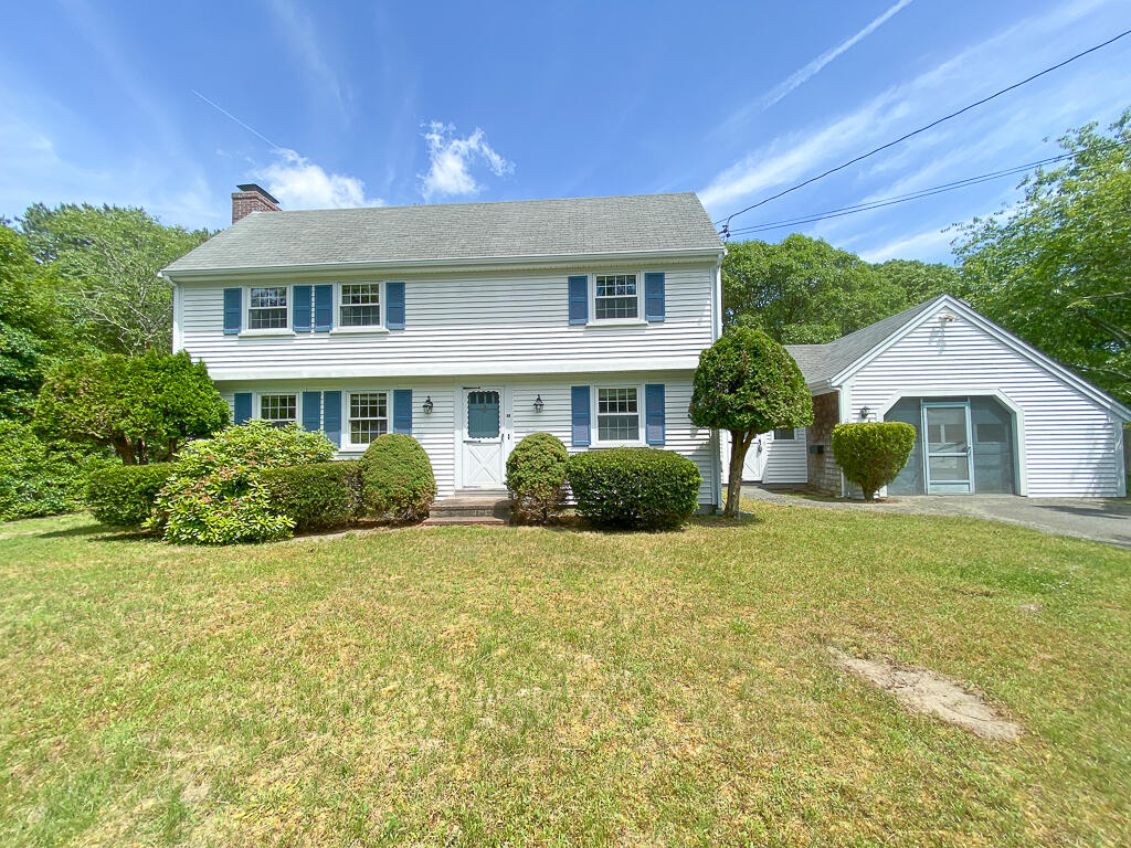 a view of a house with a big yard and potted plants