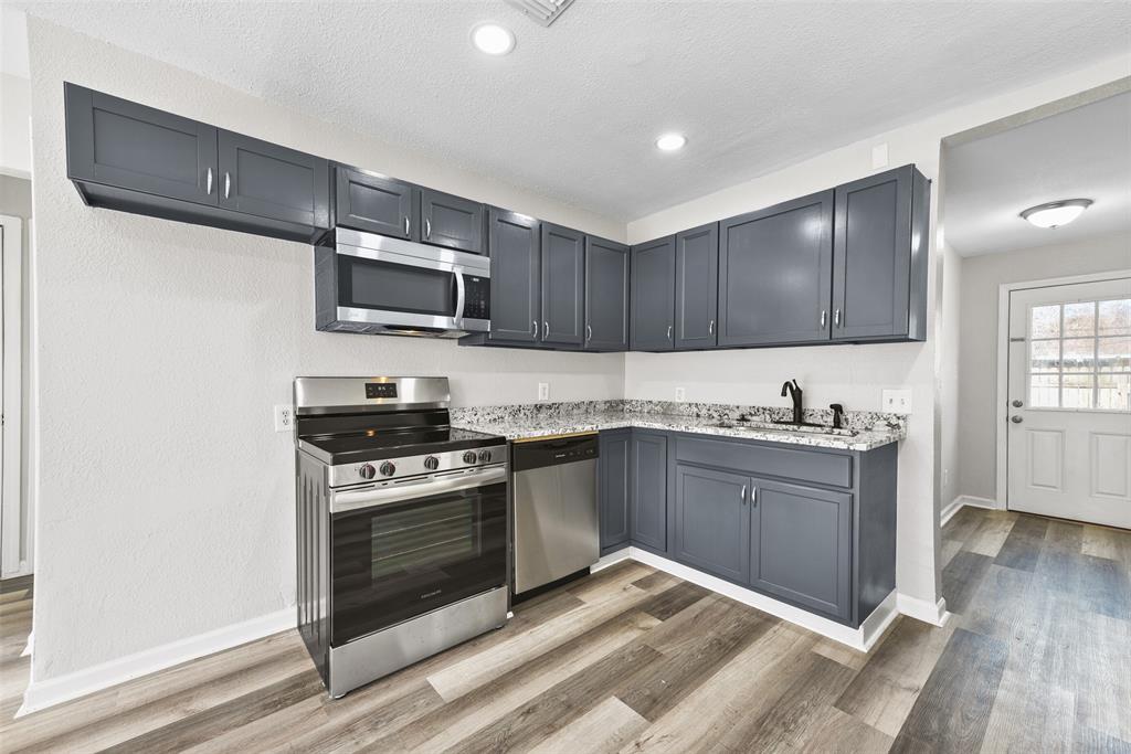 This stunning custom kitchen perfectly complements the open living space, showcasing new countertops, modern appliances, and stylish fixtures.