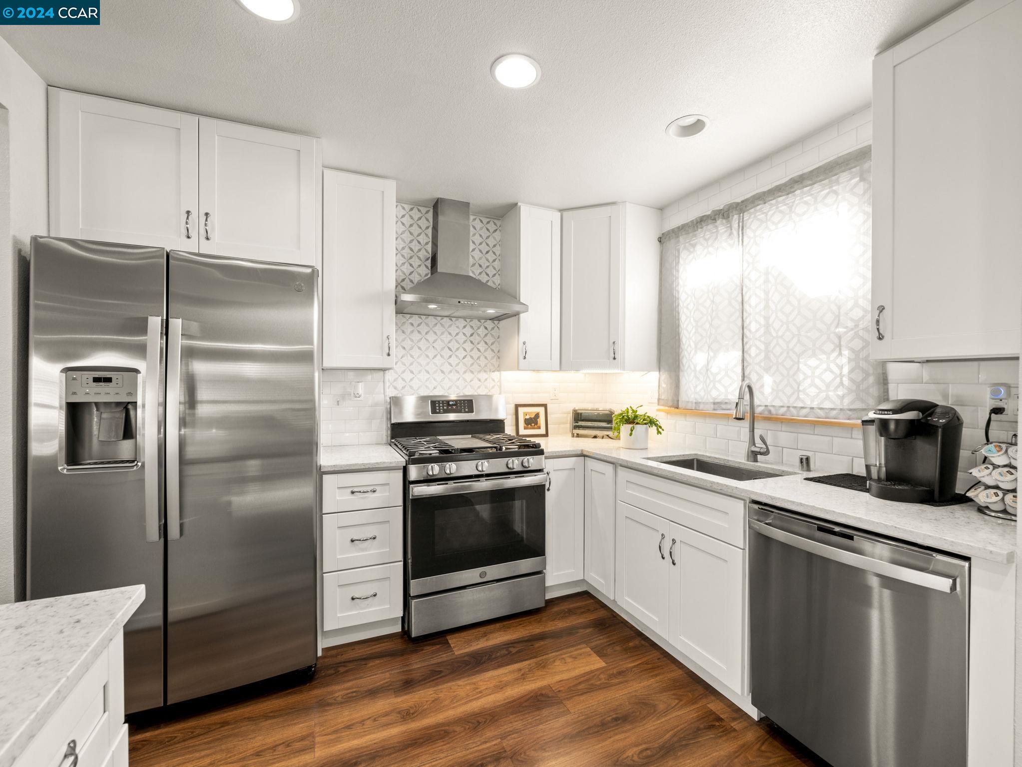 a kitchen with a sink stainless steel appliances and window