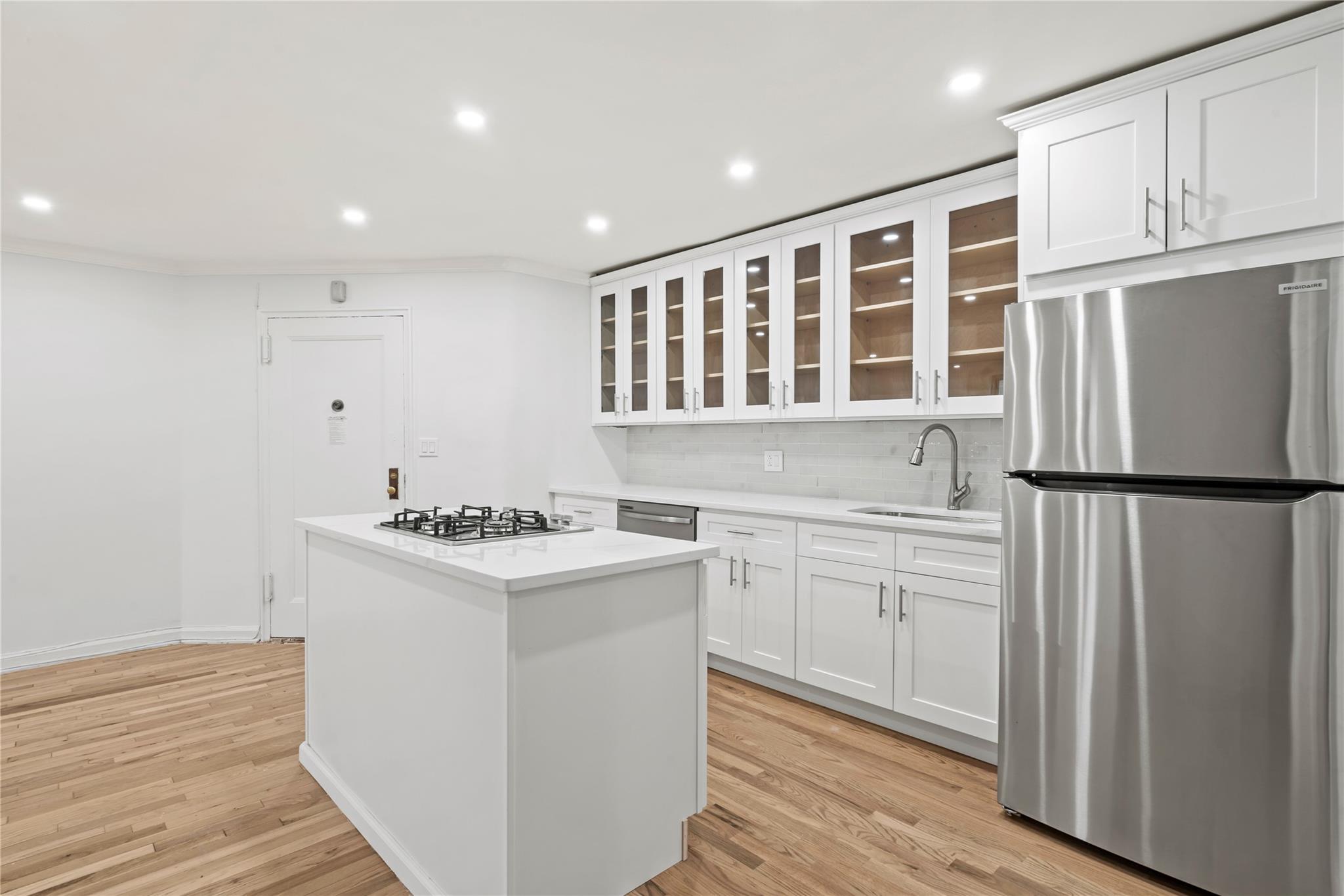 a kitchen with refrigerator cabinets and wooden floor