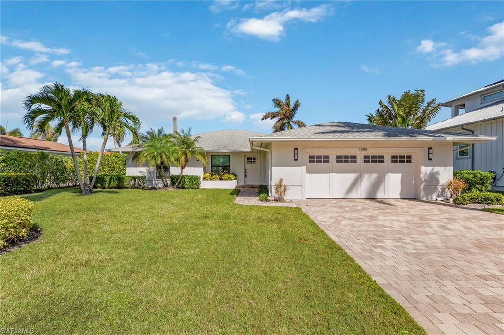 Ranch-style house with a garage and a front lawn